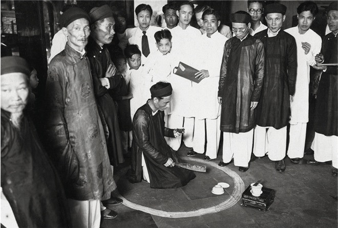 Đền Bạch Mã ở Hà Nội, tháng 4/1936. Đền thờ thần Bạch Mã (Ngựa trắng) và thờ thần Long Đỗ. Ngôi đền này cũng là nơi thường diễn ra các nghi lễ uống máu ăn thề. Trong ảnh, người chủ nợ đang ngồi đợi trong vòng vôi.