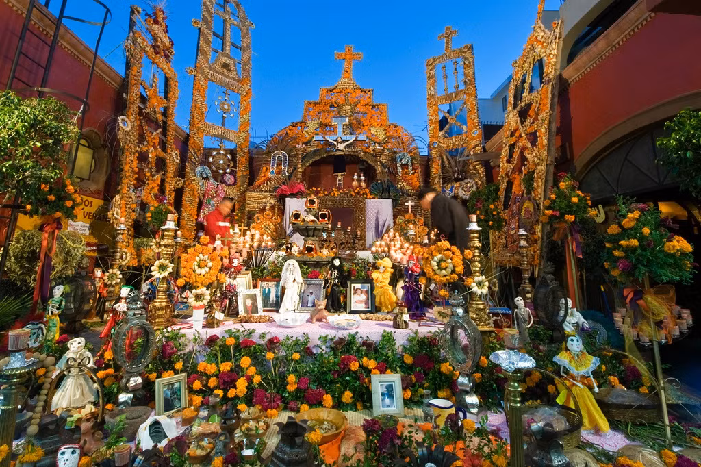 Trong lễ kỷ niệm, ban thờ được đặt tại nhà riêng và nghĩa trang. Đây là nơi chào đón những linh hồn đã khuất trở về sum vầy cùng gia đình. Góc linh thiêng này được người dân phủ khăn trắng, dán giấy họa tiết, đặt ảnh các thành viên gia đình cùng những ngọn nến nhỏ, búp bê. Ảnh: Getty.