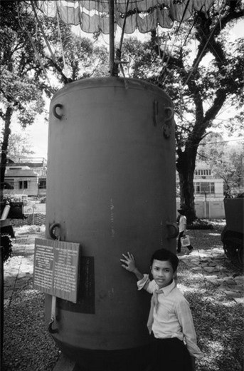 Một học sinh bên quả bom CBU-55 - một loại bom cháy dạng chùm Mỹ sử dụng trong chiến tranh Việt Nam.