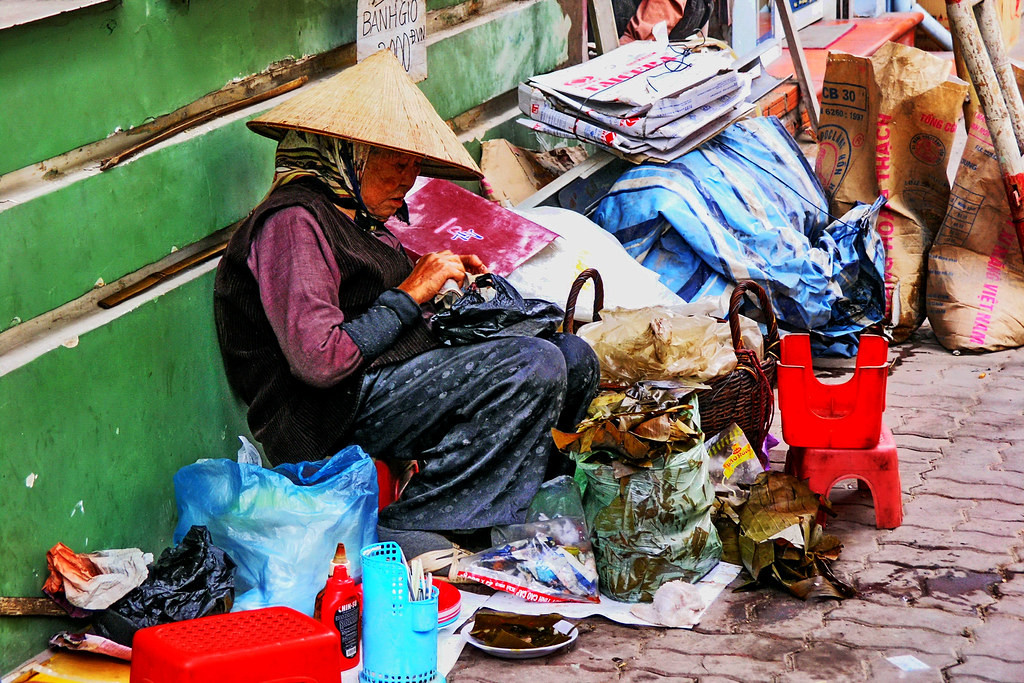 Cụ bà bán bánh giò trên vỉa hè.