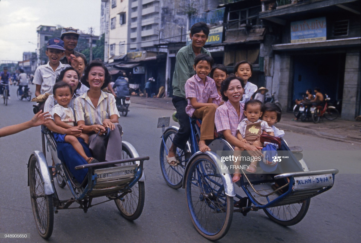 Đại gia đình trên hai chiếc xích lô, Sài Gòn năm 1987. Ảnh: Lily Franey/Gamma-Rapho/ Getty Images.