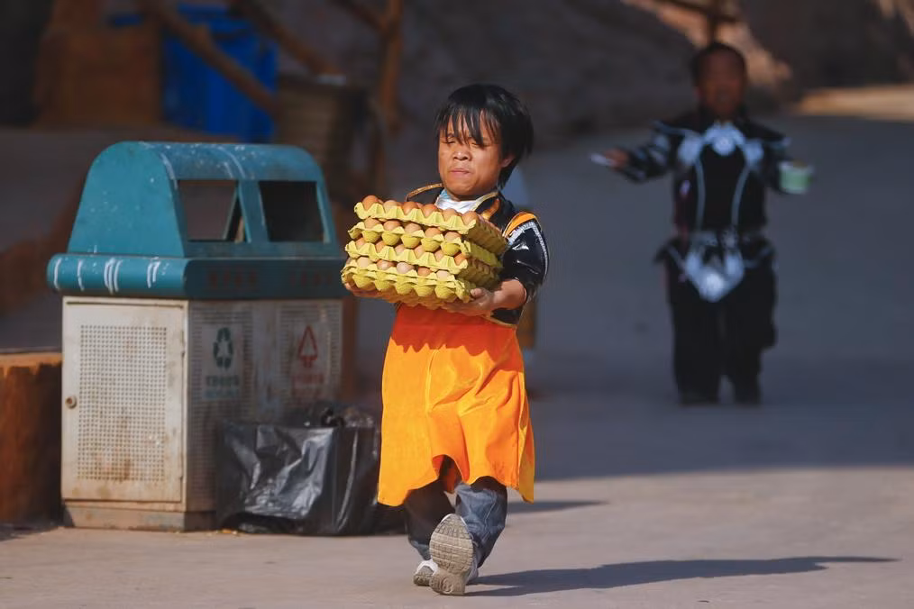 Luo Gang mang trứng tới một trong các cửa hàng trong công viên giải trí theo chủ đề vương quốc người lùn.
