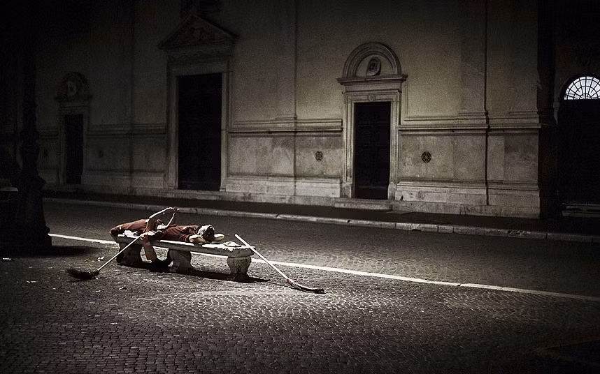 Ảnh chụp lúc 4 giờ sáng khắc họa một công nhân quét rác tranh thủ nằm nghỉ trên ghế đá tại một con phố vắng hoe của nhiếp ảnh gia Tatiana Volobueva.