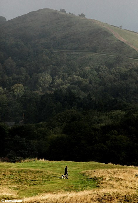 Người đàn ông dắt chó cưng đi dạo trên đồi Malvern trong một buổi sáng mùa thu tuyệt đẹp.