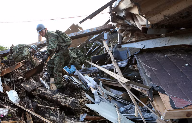 Binh sĩ Nhật Bản bới đống nhà cửa đổ nát bởi siêu bão tìm kiếm người sống sót tại đảo Oshima.