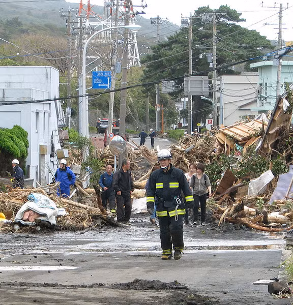 Người dân Nhật Bản bất lực nhìn đống đổ nát bao gồm cây cối và những ngôi nhà bị bão giật sập.