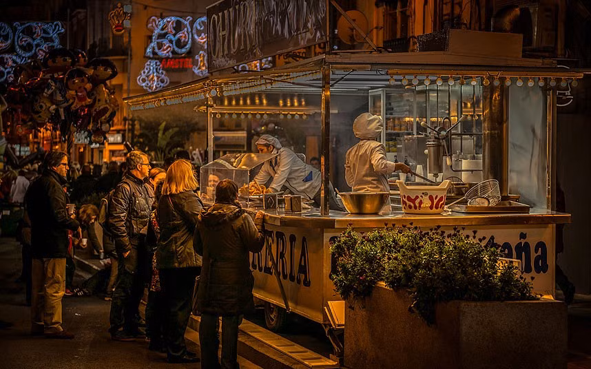 Ảnh chụp lúc 2 giờ sáng khắc họa một cửa hàng bán bánh di động ở Fallas, Valencia, Tây Ban Nha của nhiếp ảnh gia người Anh Ian Monk.