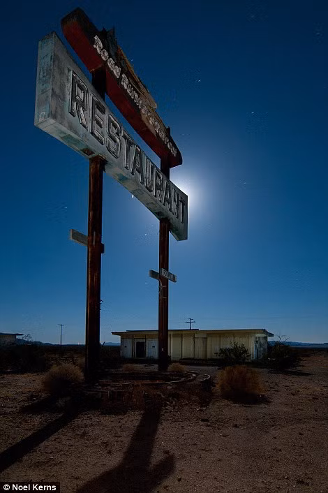 Một nhà hàng dành cho khách đi đường bên lề đường 66, đoạn ở sa mạc Mojave, phía đông Amboy, California từ lâu đóng cửa im ỉm dưới ánh trăng toát lên vẻ lạnh lẽo đầy ám ảnh.
