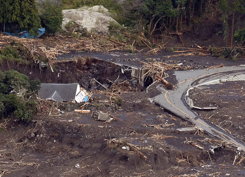 Một ngôi nhà bị sụt xuống một hố đất lớn ngay bên cạnh con đường đã bị hủy hoại nặng nề.