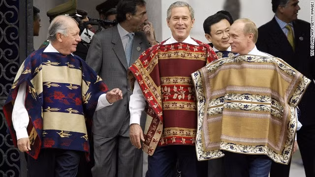 Tham dự APEC năm 2004 ở Santiago, Tổng thống Nga Putin (phải) và cựu Tổng thống Mỹ George Bush (bên cạnh ông Putin) xúng xính trong áo chui đầu truyền thống của Chile.