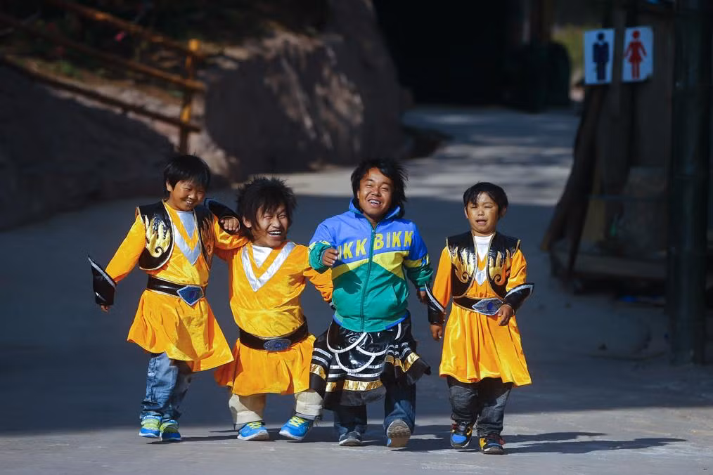 Một nhóm các cư dân của vương quốc người lùn bao gồm Du Zhuang, Zhang Jie Min, Li Ying'An và Shu Chen Jiao khoác vai nhau đi trong công viên theo chủ đề ở ngoại ô Côn Minh, Trung Quốc