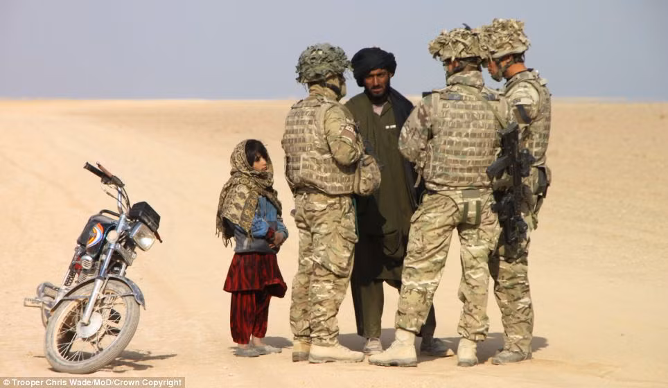 Bức ảnh được chụp bởi nhiếp ảnh gia Trooper Chris Wade, chiến thắng ở hạng mục ảnh hoạt động nghiệp dư của cuộc thi nhiếp ảnh quân đội 2013 khắc họa hình ảnh nhóm lính Anh trò chuyện với 2 cha con người Afghanistan.