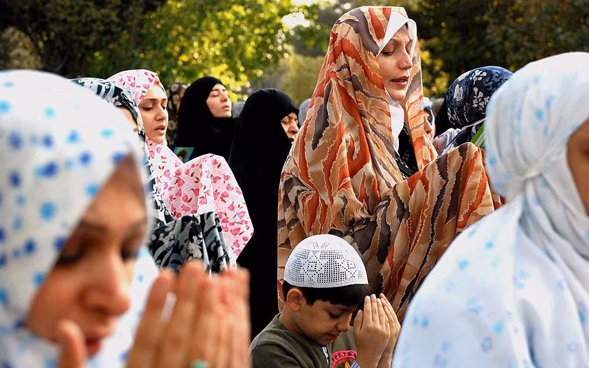 Một cậu bé người Iran cầu nguyện giữa nhóm nữ tín đồ Hồi giáo ở Tehran trong lễ Eid al-Adha.
