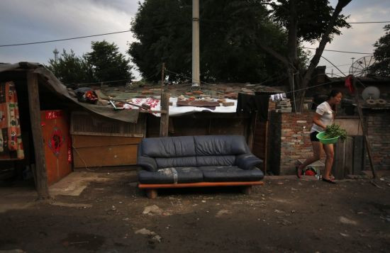 Những đưá trẻ chơi cạnh ngôi nhà được dựng lên tạm bợ trong khu ổ chuột và phía xa là một tòa nhà cao tầng tại Trung tâm thương mại Bắc Kinh.