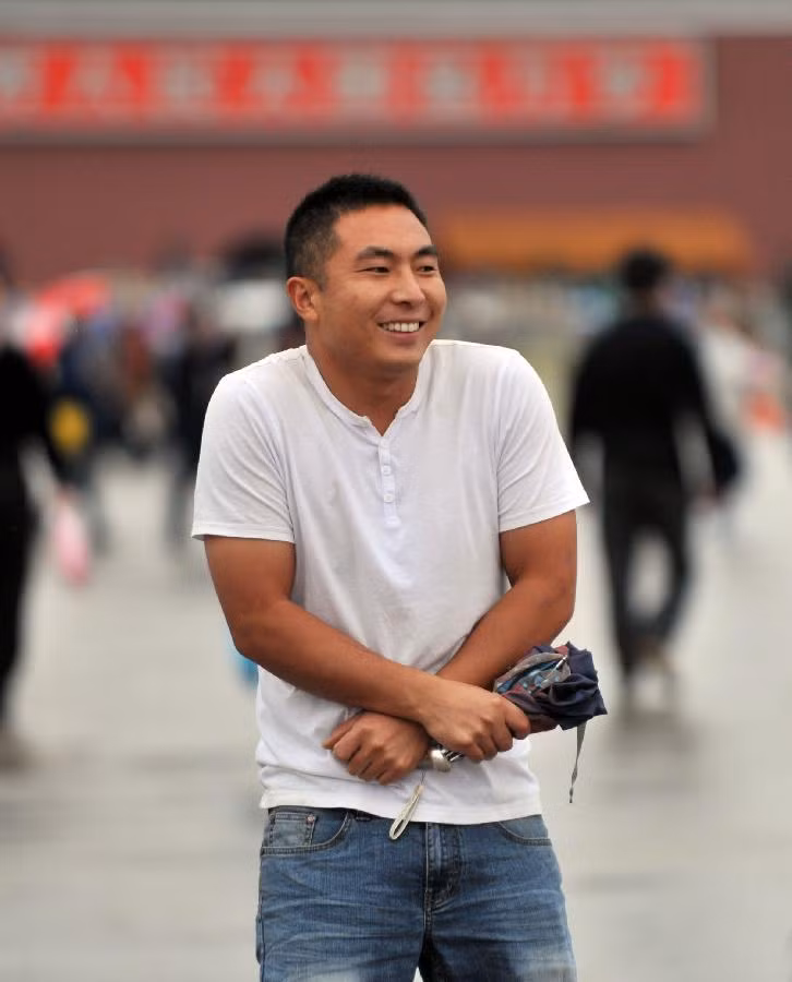 Một nam thanh niên mặc áo phông cộc tay cảm thấy ớn lạnh khi tới thăm Quảng trường Thiên An Môn ở Bắc Kinh.