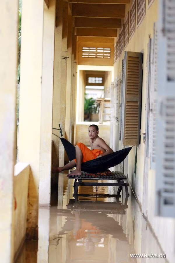 Nhà sư mắc võng trên hành lang ngập nước của một ngôi chùa ở tỉnh Kandal.