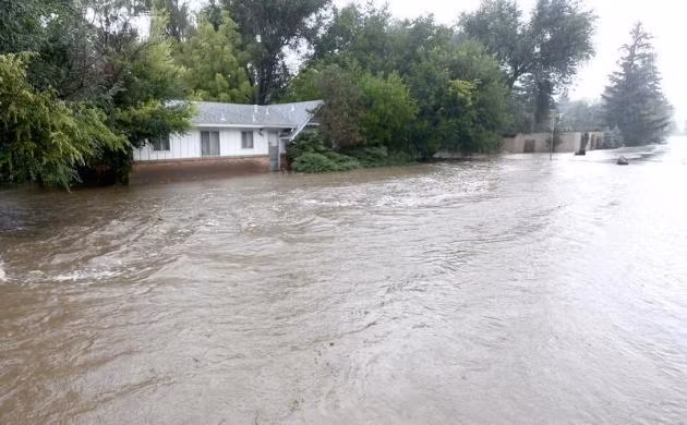 Biển nước trên đường phố và bao quanh các ngôi nhà ở Boulder.