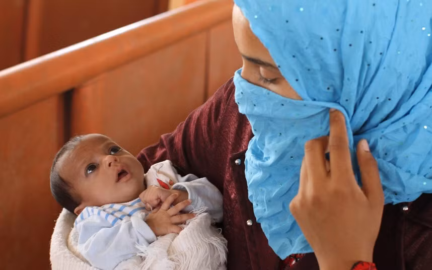 Một bà mẹ bế con con 2 tháng tuổi trong trại tị nạn Zaatari.