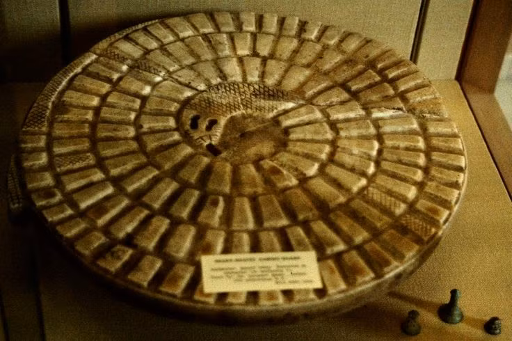  5. Mehen trong các bức tranh và điêu khắc. Mehen xuất hiện trong nhiều bức tranh và điêu khắc Ai Cập cổ, đặc biệt là trên các mộ phần và đền thờ. Hình ảnh của Mehen có thể được tìm thấy trên các tấm ván đá, nơi ông bảo vệ các vị thần hoặc các vị vua trong thế giới ngầm. Ảnh: Pinterest.