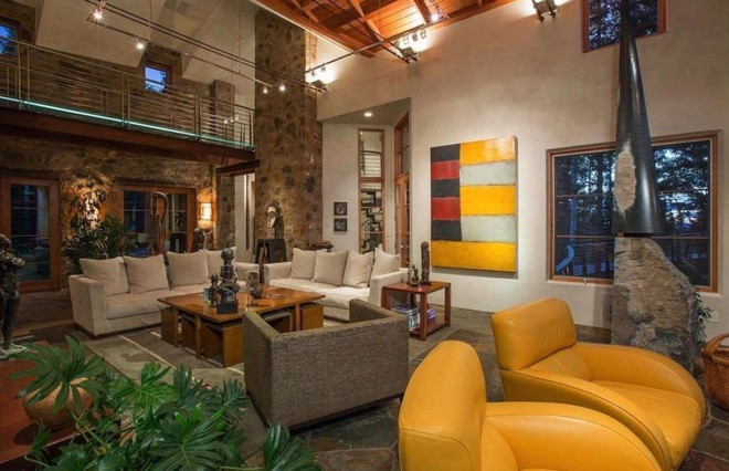 Căn nhà gỗ rộng hơn 800 m2 có được thiết kế và bài trí ấm cúng. Trong ảnh là phòng khách rộng với lò sưởi bằng đá lớn. Ảnh: Zillow.