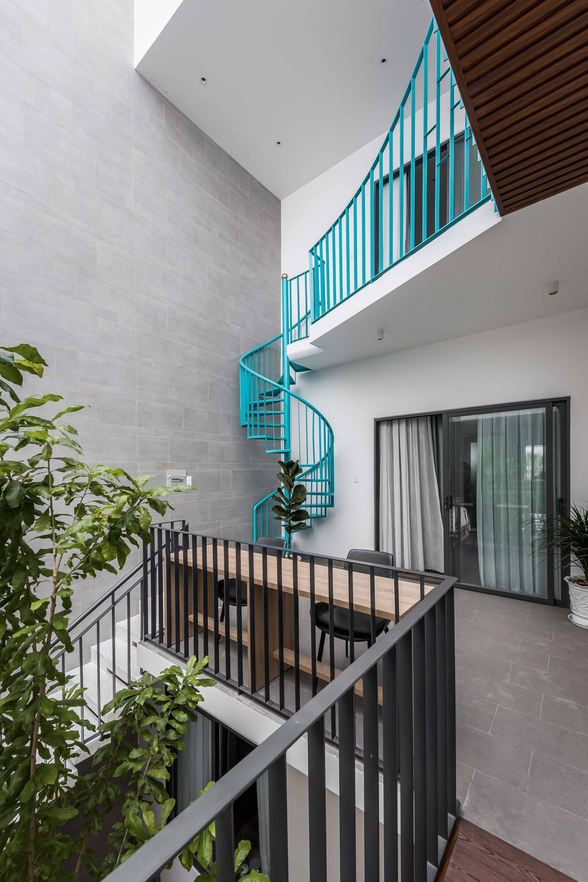 Sự xuất hiện cây cầu màu xanh tạo một điểm nhấn giữa nhà, làm cho ngôi nhà trở nên đặc biệt. Tính thư giãn và sự sinh động từ hình ảnh chiếc cầu xanh cũng giúp giải tỏa nhiều áp lực khi mọi người ở nhà. Khoảng không gian điệm hai bên cây cầu trở thành nơi vui chơi, học tập của các bạn nhỏ.