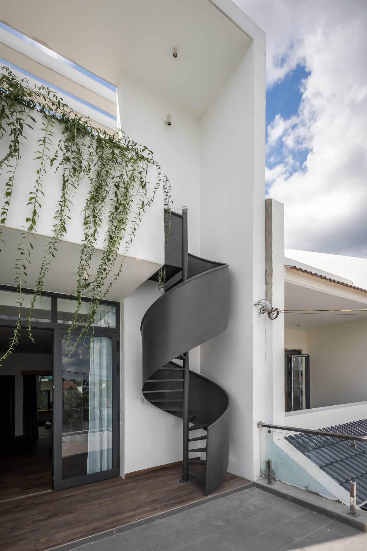 Cầu thang ngoài ban công không những giúp gia chủ dễ dàng di chuyển mà thiết kế uốn lượn còn tạo mặt tiền nổi bật.