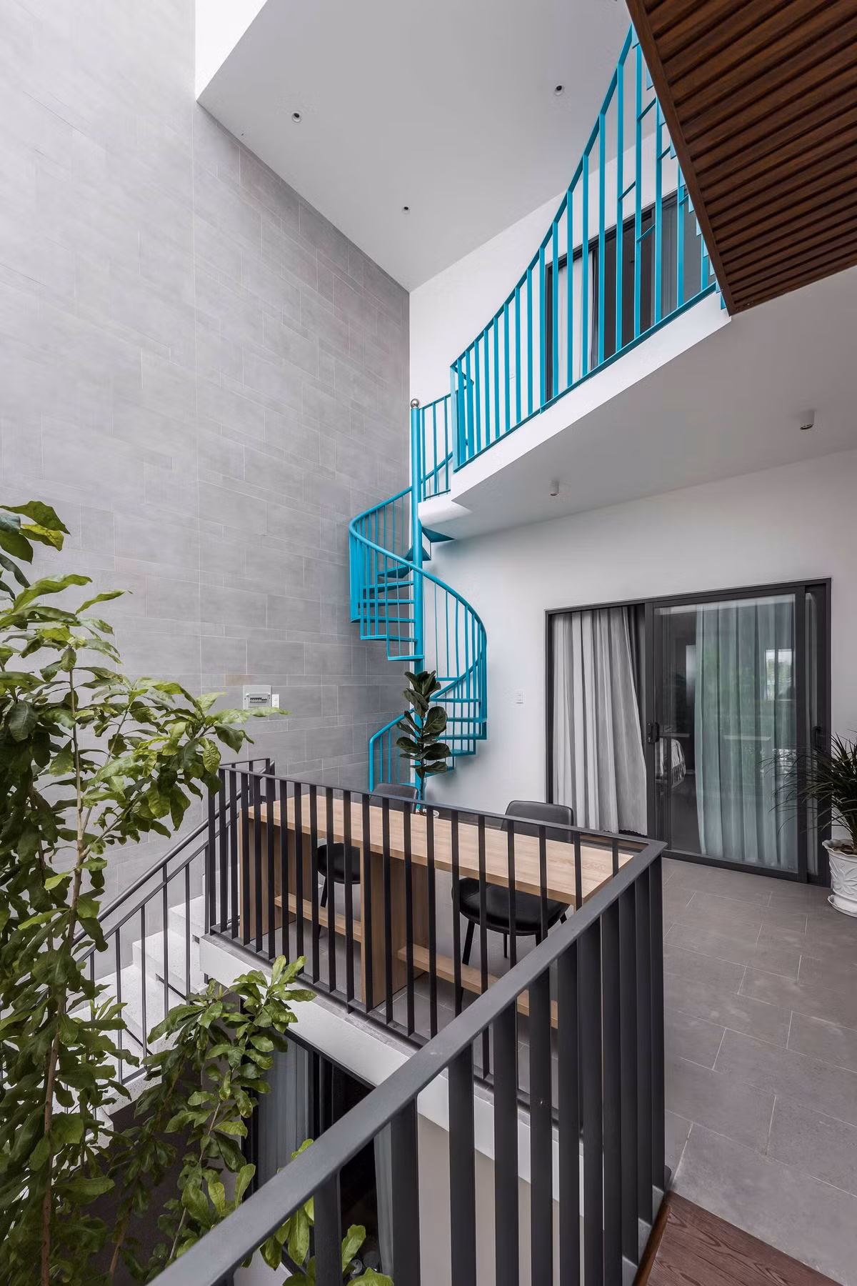 Cầu thang dẫn lên tầng 3 cùng màu với lam sắt cây cầu tạo ra sự đồng điệu, liền mạch.