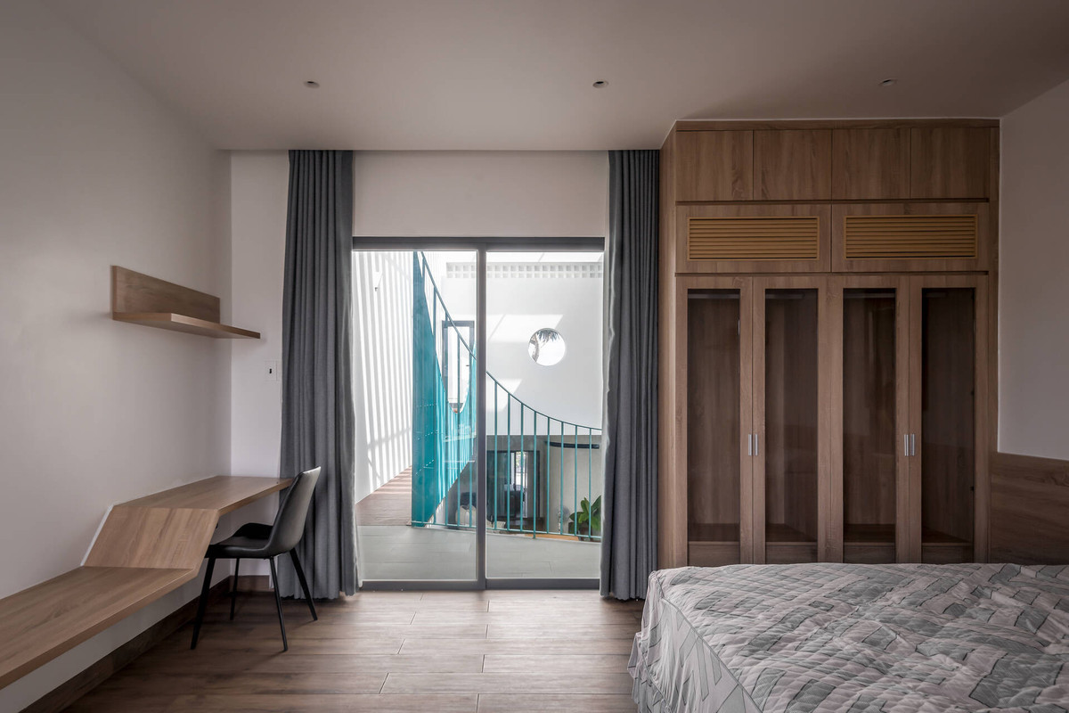 Các phòng ngủ tối giản có thiết kế cửa kính để nhận trọn vẹn ánh sáng từ giếng trời cũng như kết nối hơn với các thành viên khác. Không gian sử dụng ít nội thất để mang lại cảm giác thoải mái, dễ chịu.