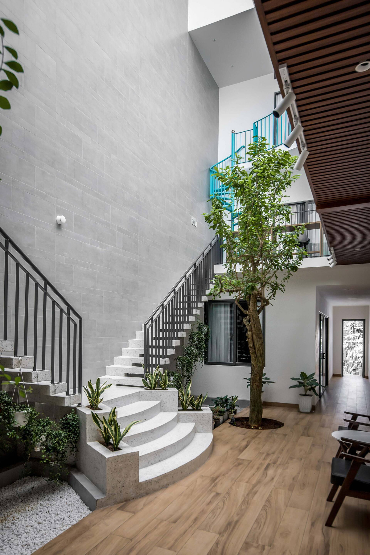 Để đáp ứng đủ số lượng phòng ngủ nhưng vẫn đảm bảo ánh sáng, sự thông thoáng cho các phòng, đội ngũ kiến trúc sư đã đưa ra giải pháp tách căn nhà thành hai khối, tạo ra một khoảng sân ở giữa.