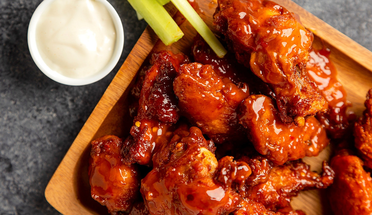 Cánh gà Buffalo (Mỹ): Hương vị cay nồng được tạo nên bởi hỗn hợp nước sốt bao gồm ớt cayenne, bơ, giấm, bột tỏi và sốt Worcestershire. Cánh gà nướng sốt ớt được phục vụ với cần tây và phô mai xanh để làm cân bằng hương vị. Ảnh: Todd Taulman/Getty Images.