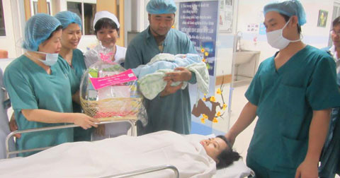 TS.BS Huỳnh Thị Thu Thủy, Phó giám đốc Bệnh viện Từ Dũ trao quà cho chồng chị Xinh.