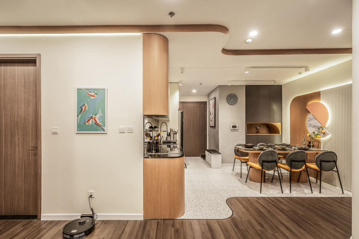 Phòng khách và bếp được thiết kế theo không gian mở. Khu vực này được phân chia hợp lý nhờ vào việc sử dụng hai loại gạch có họa tiết khác nhau nhưng kết hợp hài hòa và phù hợp. Việc sử dụng đường cong uốn lượn ngay tại vị trí chuyển đổi giúp loại bỏ cảm giác thô cứng.