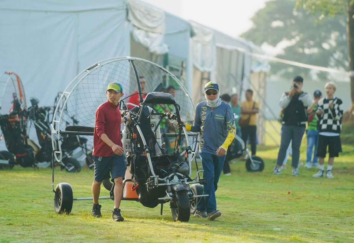  Ngày 9/12, tại bãi cỏ bên trong công trường Khu đô thị The Global City (thành phố Thủ Đức), các thành viên phục vụ mặt đất của đội bay CloudSurf phải tất bật chuẩn bị máy móc phục vụ cho du khách, người dân đến trải nghiệm môn thể thao dù lượn ngắm TP Hồ Chí Minh từ trên cao.