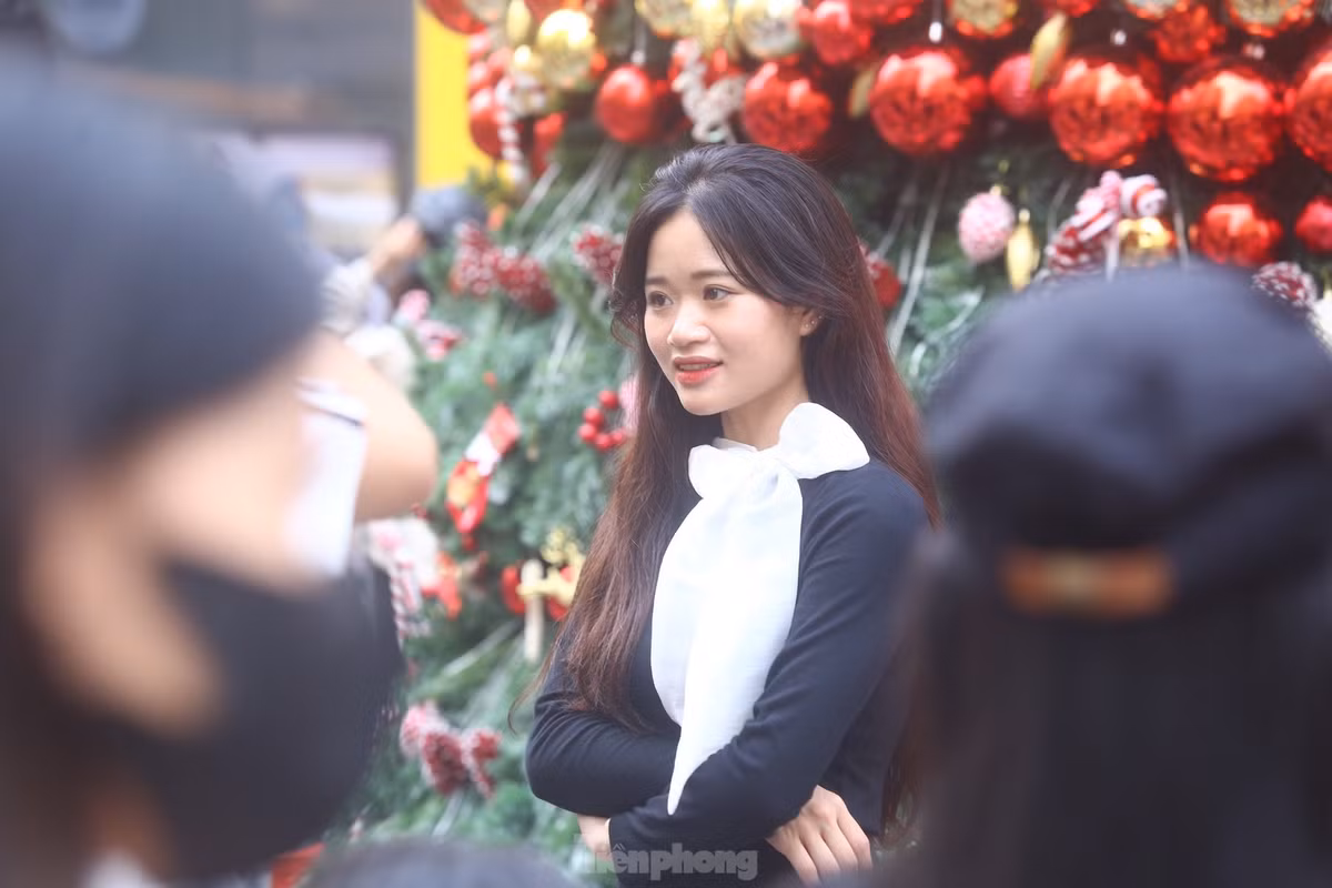 Thiếu nữ thả dáng dưới cây thông Noel.