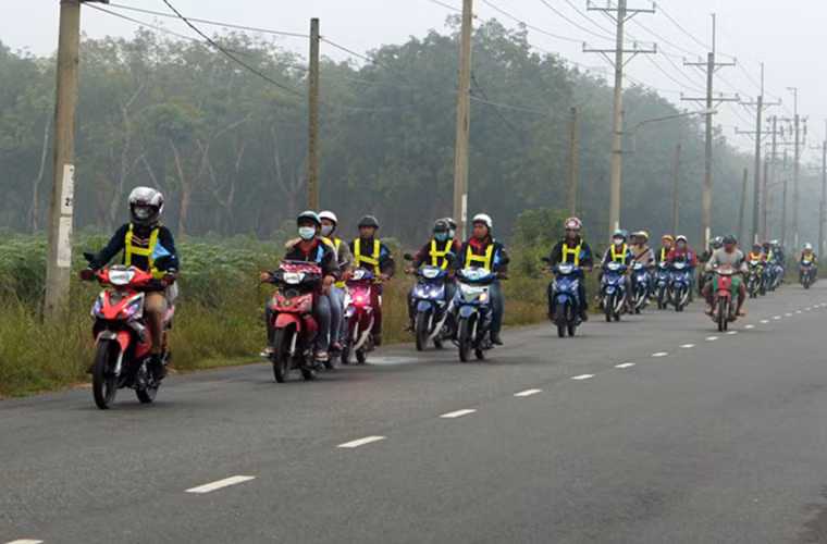 Đoàn xe di chuyển qua khu vực rừng cao su thuộc huyện Nhơn Trạch. Các thành viên đều mặc áo phản quang và đi thành một hàng để đảm bảo an toàn.