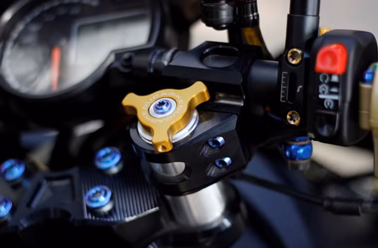 Hai con chốt tán ghi đông hiệu Ducabike màu vàng chính hãng của Ý, hai ốc Proti màu xanh là điểm nhấn nổi bật trên dàn đầu.