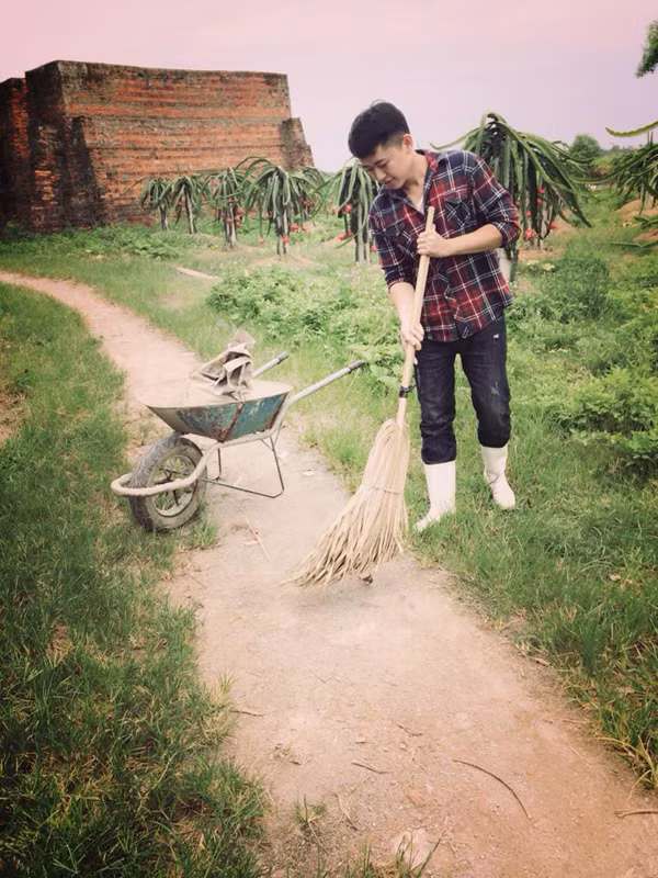 Anh chàng điển trai Bùi Thành An phụ giúp bố mẹ quét vườn cây.