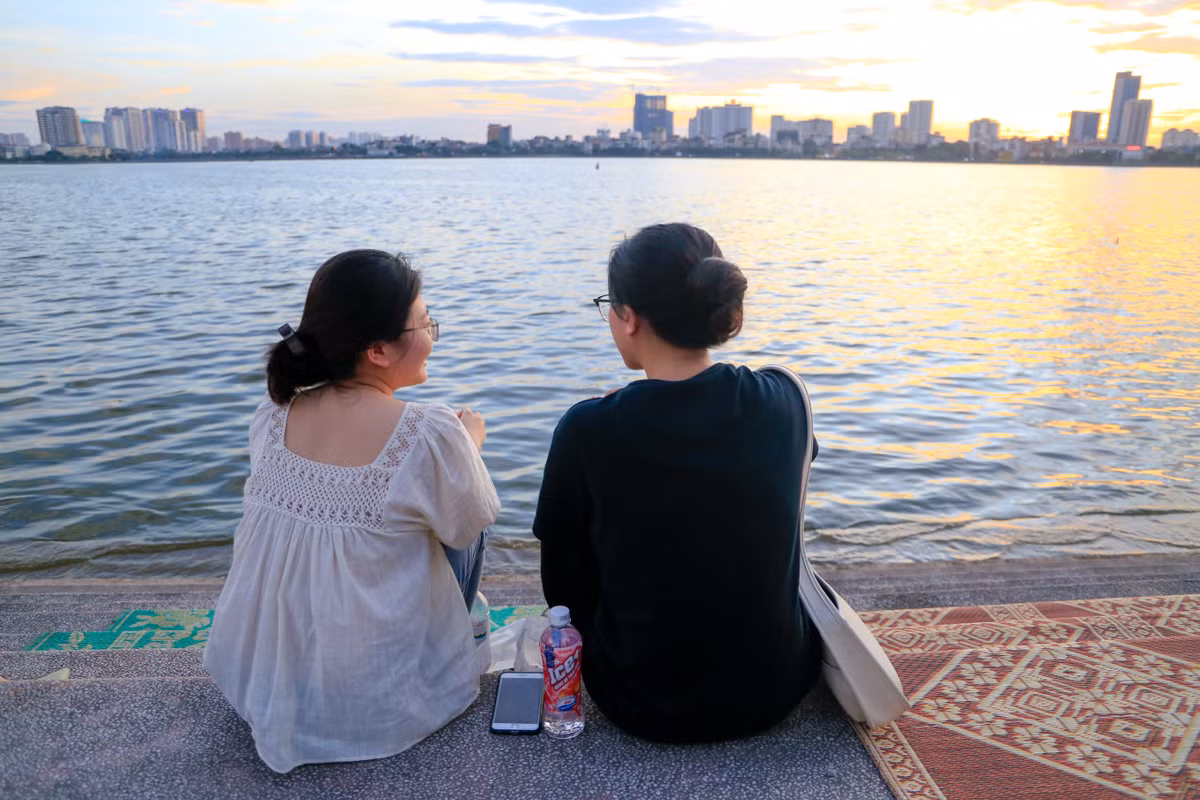 Nhung và Mai (sinh năm 1999) mua thêm nước uống, đồ ăn vặt trong lúc ngồi ở mạn hồ. "Thời tiết không khiến bọn mình khó chịu lắm bởi trời nắng to mới dễ có hoàng hôn đẹp, cũng không sợ tốn xăng vì lâu rồi mới đi lượn. Nay bọn mình nổi hứng lên hồ Tây, cảm giác giống như ôn lại thời sinh viên khi có nhiều thời gian rảnh, còn giờ hai đứa đều đã đi làm, 2-3 tháng mới ghé qua đây lúc cuối chiều", Mai chia sẻ.