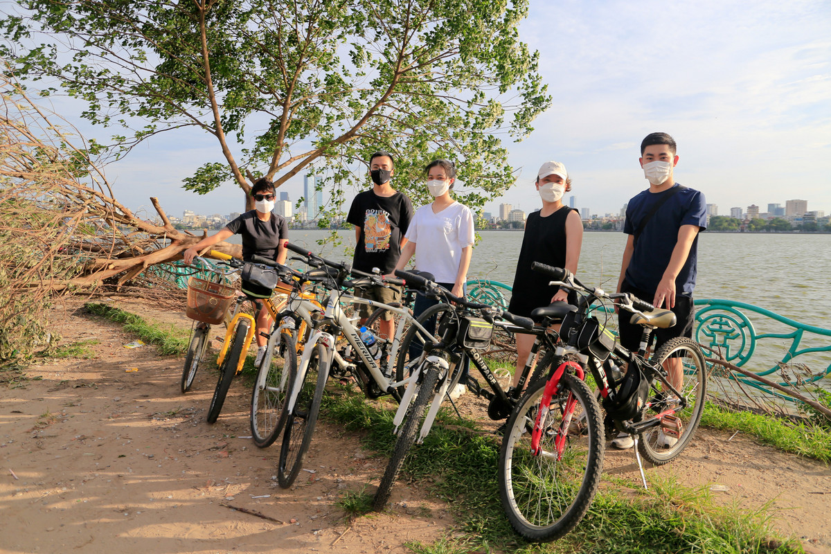 Trên đường đạp xe quanh hồ Tây, nhóm bạn 5 người quyết định tạt qua gốc "cây cô đơn" để check-in tập thể theo lời gợi ý của một người bạn. Một thành viên trong nhóm cho biết đây là lần đầu anh đến sát gốc cây chụp ảnh, trước đó chỉ đi qua.