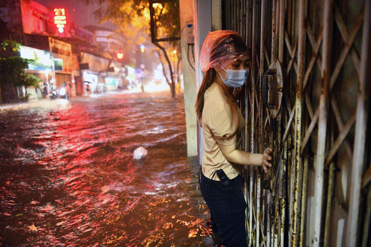 Đặng Diễm, nhân viên một cửa hàng thuốc trên phố Đội Cấn đi làm về lúc 21h. “Đây là lần thứ hai em phải lội nước về nhà trong tháng này. Em xác định là ướt hết người rồi”, Diễm chia sẻ. Ảnh: Thạch Thảo.
