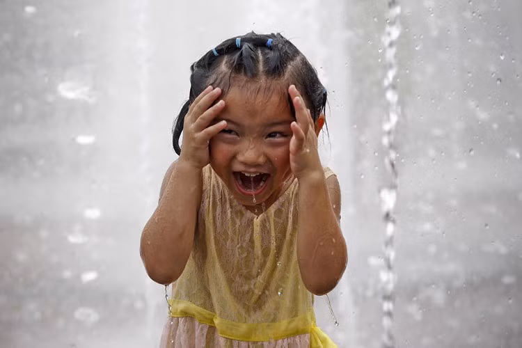 Bức ảnh chụp ngày 11/8 mô tả một bé gái đang tắm mình ở đài phun nước để hạ nhiệt khi Thượng Hải tiếp tục nóng như thiêu, như đốt, thậm chí khiến một số người thiệt mạng vì say nắng.