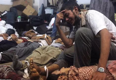 Một người đàn ông khóc lóc thảm thiết giữa thi thể của hàng trăm người sau các vụ đụng độ đẫm máu với quân đội chính phủ hôm qua.