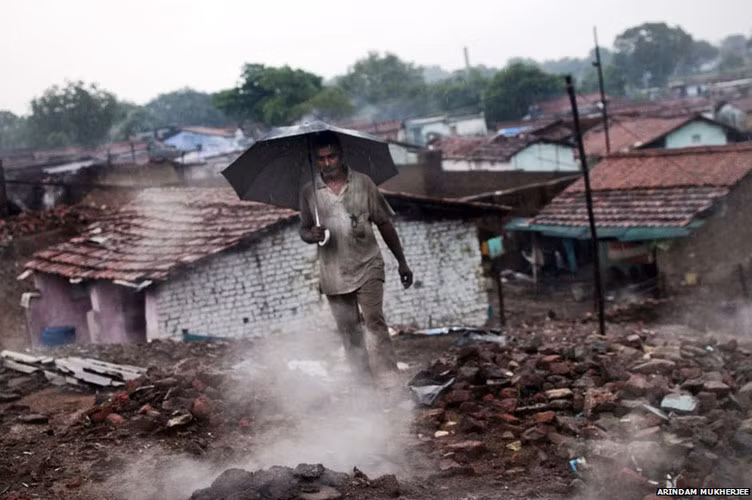 Một người đàn ông đi qua khu ổ chuột lụp xụp ở Indra Chowk, gần thị trấn Jharia. Cư dân ở đây cho biết, ngọn lửa từ Jharia đã lan rộng tới nhà họ trong 10 năm qua.