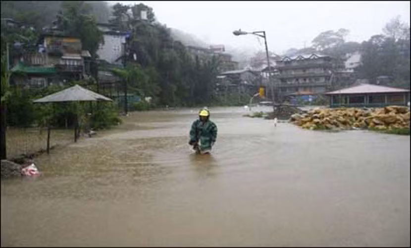 Một người dân Philippines lội bì bõm trong nước lũ.