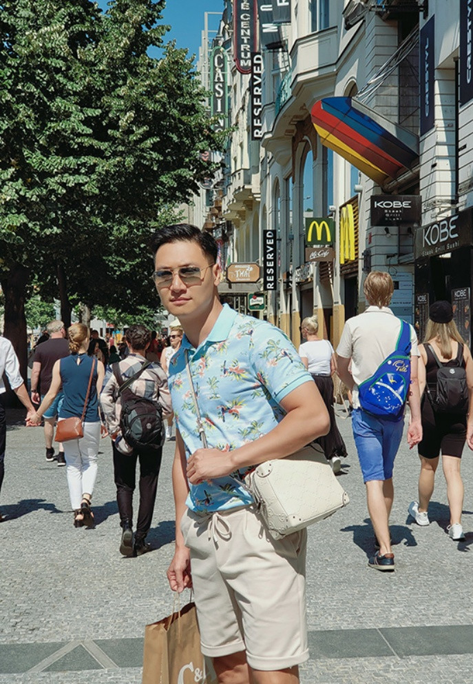 Mạnh Trường bị trêu "nữ tính" vì diện áo hoa, đeo túi của vợ khi đi mua sắm.