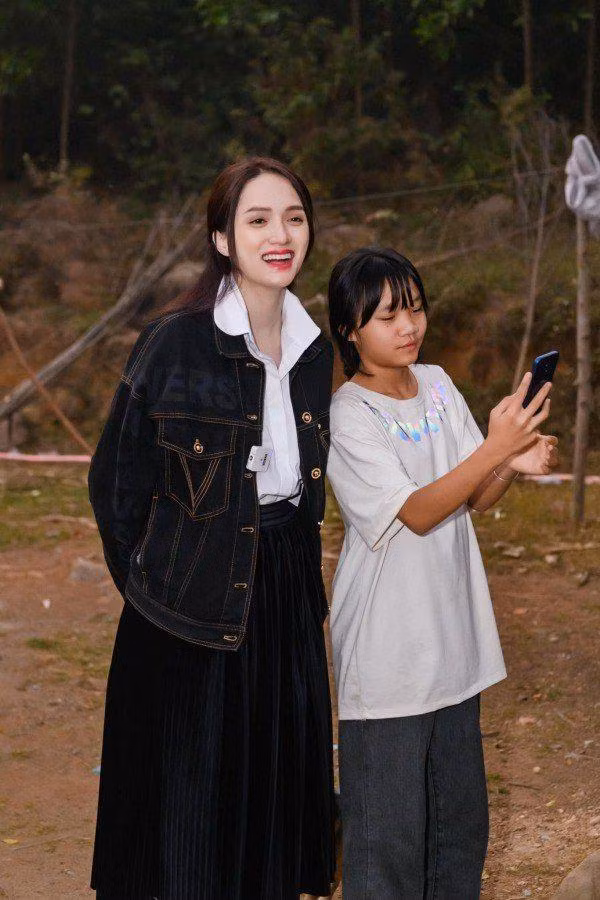 Áo sơ mi trắng phối cùng chân váy xếp ly, khoác thêm áo denim giúp outfit của Hương Giang trông chẳng khác gì thiếu nữ.