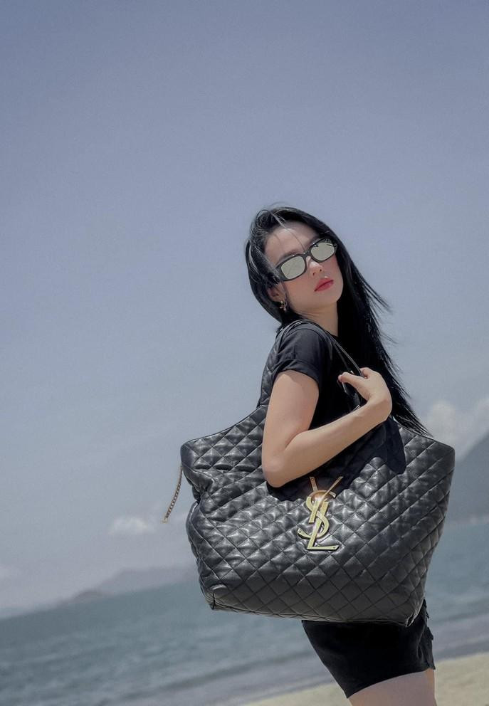 Minh Hằng tạo dáng bên túi hiệu trong chuyến đi chơi biển cuối tuần.