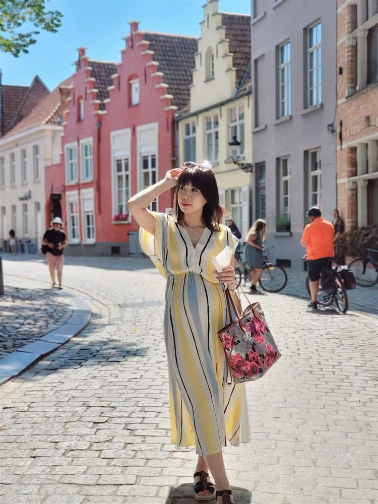 Lan Phương diện váy kẻ sọc để hack dáng thon thả, màu sắc tươi tắn. Check-in từ Pháp sang Bỉ, vợ Mạnh Trường diện váy vóc không trùng bộ nào. Dù bầu bí khá to ở khoảng tháng thứ 4-5 nhưng Lan Phương vẫn tươi tắn, rạng rỡ. Cô ưu ái chọn những thiết kế có phom rộng, xòe, màu sắc cùng giày dép bệt để tiện di chuyển. Những item này cũng giúp bà xã Mạnh Trường giấu bụng đáng kể.