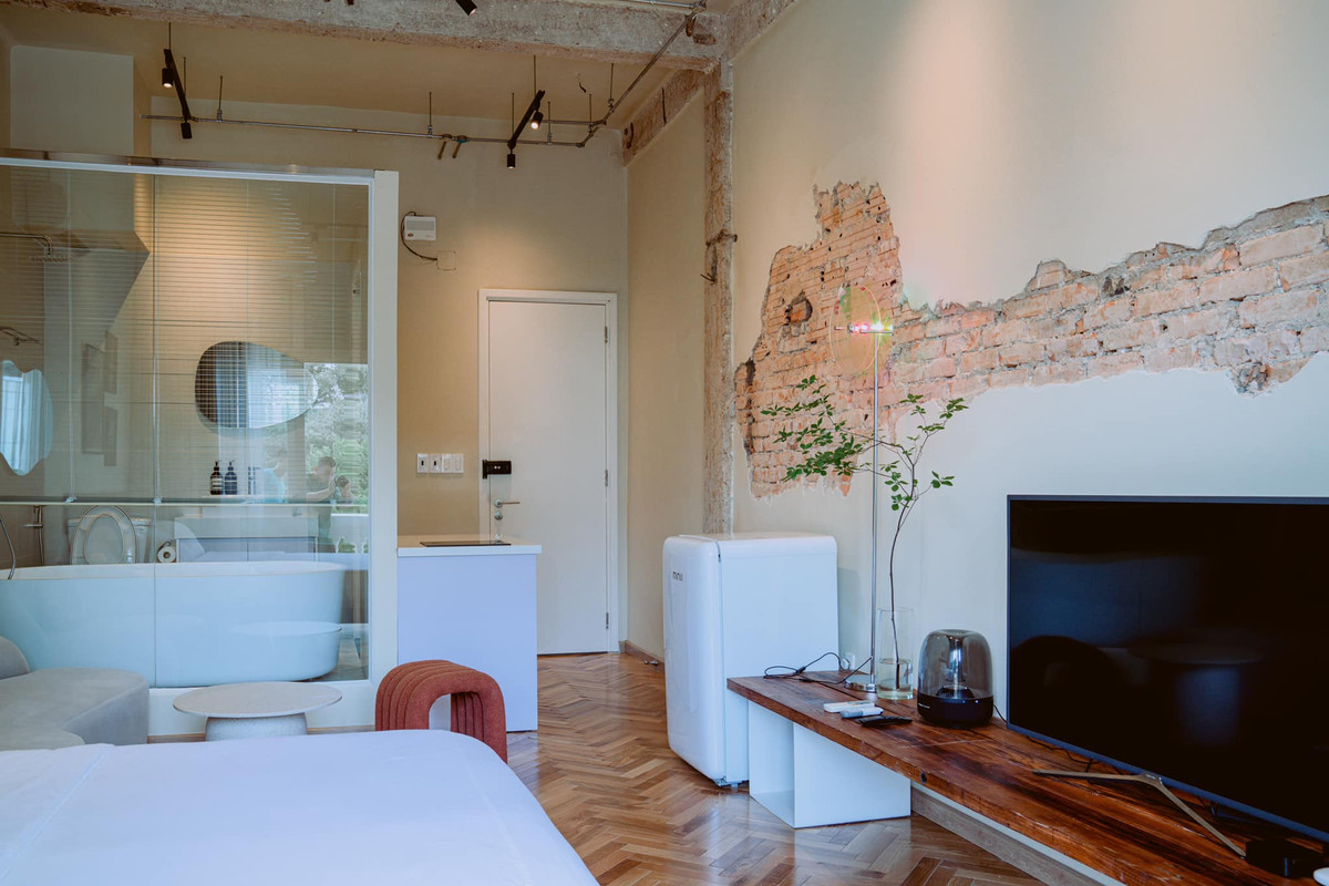 Mảng tường đục vữa, để gạch mộc kết hợp cột bê-tông thô tạo nên dấu ấn hoàn hảo cho căn hộ.