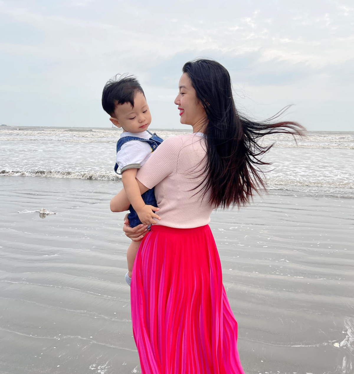 Thúy Vân bồng con dạo biển.